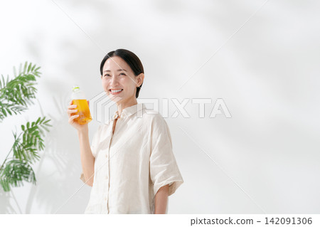 女人從一個塑料瓶喝茶 女人從一個塑料瓶喝茶 142091306