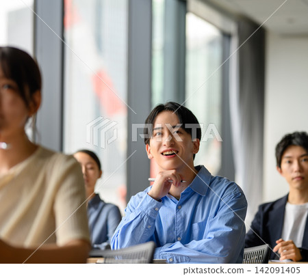 A young man listening attentively during the training session. A young man listening attentively during the training session. 142091405