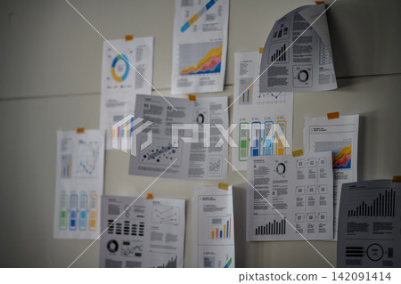 An office scene with graphs and charts posted on the wall. An office scene with graphs and charts posted on the wall. 142091414