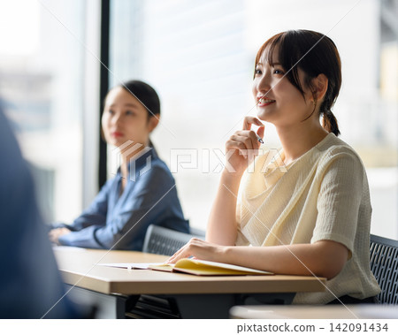 一位年輕女子正在研討會上聽講座 142091434