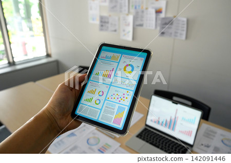 This is a business scenario where data is compared and analyzed using tablets and laptops. This is a business scenario where data is compared and analyzed using tablets and laptops. 142091446
