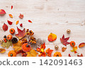 Fallen leaves and an orange pumpkin frame 142091463