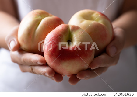 Fresh organic nectarines holding by woman hand Fresh organic nectarines holding by woman hand 142091630