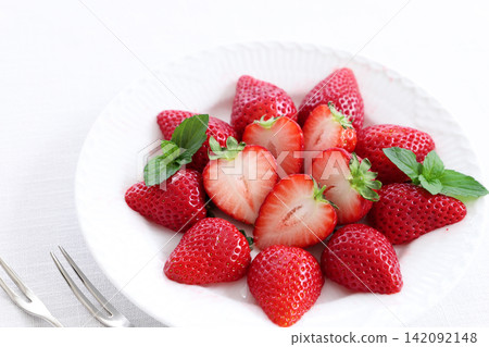 Strawberry dessert on a white plate with mint leaves 142092148