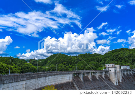 Majestic cumulus clouds above the dam; Nunome Dam; 35mm; blank space above for copying; horizontal composition with large sky; suitable for B0 poster. Majestic cumulus clouds above the dam; Nunome Dam; 35mm; blank space above for copying; horizontal composition with large sky; suitable for B0 poster. 142092283