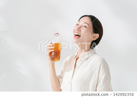 女人從一個塑料瓶喝茶 女人從一個塑料瓶喝茶 142092358