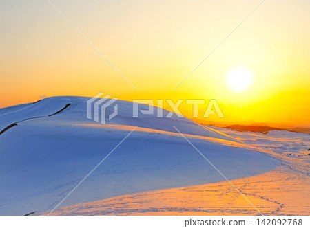 The snow-covered Tottori Sand Dunes glow orange in the setting sun. The snow-covered Tottori Sand Dunes glow orange in the setting sun. 142092768