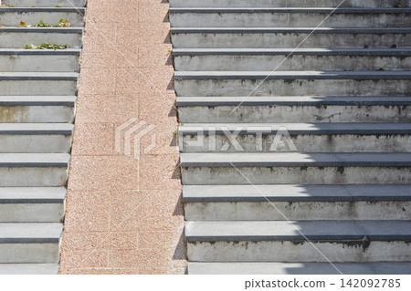 Outdoor concrete staircase with a stone stroller ramp and shadows Outdoor concrete staircase with a stone stroller ramp and shadows 142092785