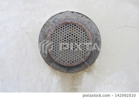 Old rusty metal ventilation grate on a concrete wall 142092810