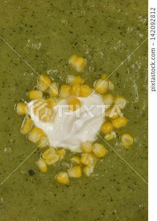 Close up of green zucchini cream soup with corn and sour cream Close up of green zucchini cream soup with corn and sour cream 142092812