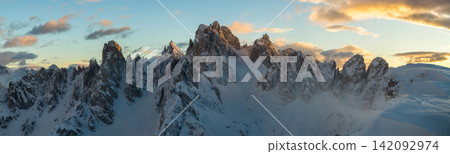 Panoramic winter view of the Dolomites at sunset with dramatic rocky peaks and snow covered ridges under colorful clouds, showcasing majestic alpine scenery in high resolution. Panoramic winter view of the Dolomites at sunset with dramatic rocky peaks and snow covered ridges under colorful clouds, showcasing majestic alpine scenery in high resolution. 142092974