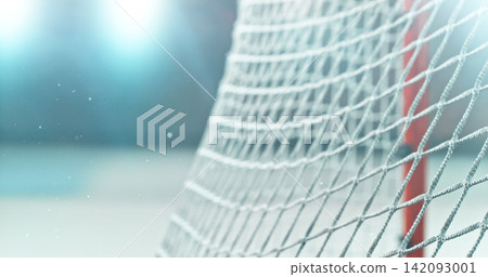 Close-up detail of an ice hockey goal net inside an indoor rink, with shallow depth of field and blurred background, capturing sports atmosphere and texture of the net mesh. Close-up detail of an ice hockey goal net inside an indoor rink, with shallow depth of field and blurred background, capturing sports atmosphere and texture of the net mesh. 142093001