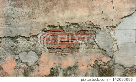 A weathered vintage wall with exposed red brickwork and peeling plaster. 142093096