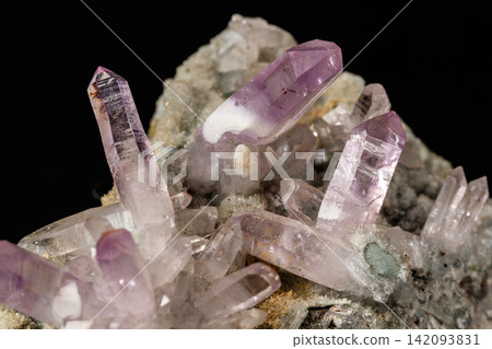 Macro mineral stone Amethyst crystals in rock on a black background Macro mineral stone Amethyst crystals in rock on a black background 142093831