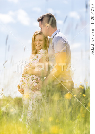 Young happy pregnant couple hugging in nature. Concept of love, relationship, care, marriage, family creation, pregnancy, parenting Young happy pregnant couple hugging in nature. Concept of love, relationship, care, marriage, family creation, pregnancy, parenting 142094259