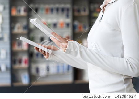 Woman Choosing Between Products While Shopping In Electronics Store. Product Options, Consumer Preference, Retail Selection And Purchase Choice Concept. Woman Choosing Between Products While Shopping In Electronics Store. Product Options, Consumer Preference, Retail Selection And Purchase Choice Concept. 142094627