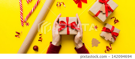 Woman hands holding gift box, preparing surprise for holiday, top view, Christmas and New Year concept Woman hands holding gift box, preparing surprise for holiday, top view, Christmas and New Year concept 142094694