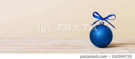 Christmas ball on colored background. decoration bauble with ribbon bow with copy space Christmas ball on colored background. decoration bauble with ribbon bow with copy space 142094720
