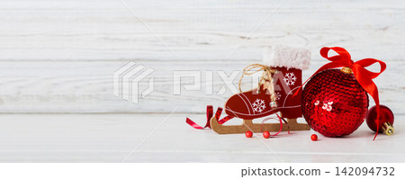 Christmas ball with skates on colored background. decoration bauble with ribbon bow with copy space Christmas ball with skates on colored background. decoration bauble with ribbon bow with copy space 142094732