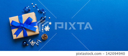 Top view Flat lay Christmas decorations and gift box on colored background with copy space. Christmas or Happy New Year composition Top view Flat lay Christmas decorations and gift box on colored background with copy space. Christmas or Happy New Year composition 142094940