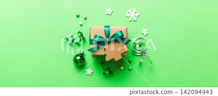 Top view Flat lay Christmas decorations and gift box on colored background with copy space. Christmas or Happy New Year composition Top view Flat lay Christmas decorations and gift box on colored background with copy space. Christmas or Happy New Year composition 142094943