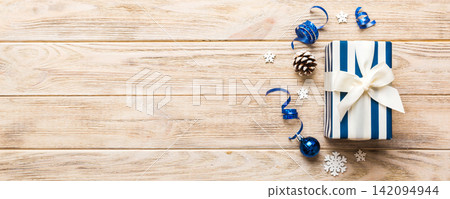 Top view Flat lay Christmas decorations and gift box on colored background with copy space. Christmas or Happy New Year composition Top view Flat lay Christmas decorations and gift box on colored background with copy space. Christmas or Happy New Year composition 142094944