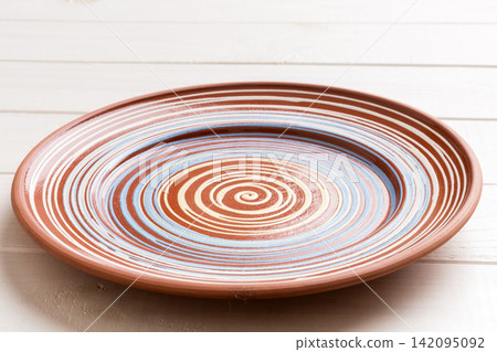 Perspective view of empty colorful plate on wooden background. Empty space for your design 142095092