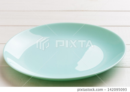 Perspective view of empty blue plate on wooden background. Empty space for your design Perspective view of empty blue plate on wooden background. Empty space for your design 142095093