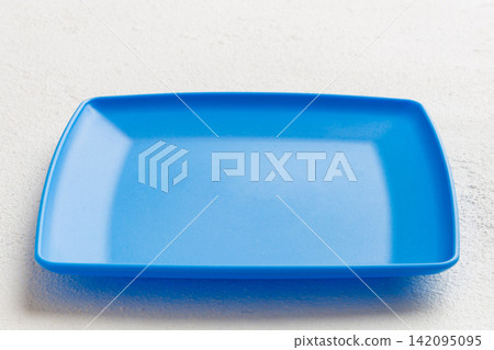 Perspective view of empty square plate on cement background. Empty space for your design Perspective view of empty square plate on cement background. Empty space for your design 142095095