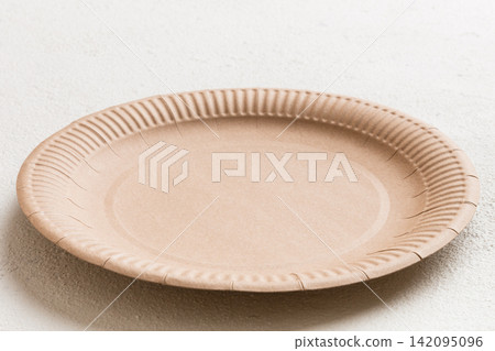 Perspective view of eco paper plate on cement background. Empty space for your design Perspective view of eco paper plate on cement background. Empty space for your design 142095096