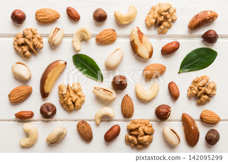 Composition of nuts , flat lay - mix hazelnuts, cashews, almonds on table background. healthy eating concepts and food background Composition of nuts , flat lay - mix hazelnuts, cashews, almonds on table background. healthy eating concepts and food background 142095299