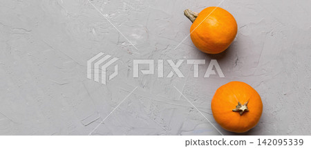 Autumn composition of little orange pumpkins on colored table background. Fall, Halloween and Thanksgiving concept. Autumn flat lay photography. Top view vith copy space Autumn composition of little orange pumpkins on colored table background. Fall, Halloween and Thanksgiving concept. Autumn flat lay photography. Top view vith copy space 142095339