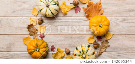 Autumn composition Pumpkins with fall leaves over coloredbackground. Top view with copy space Autumn composition Pumpkins with fall leaves over coloredbackground. Top view with copy space 142095344