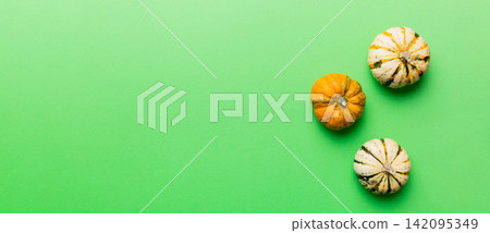Autumn composition of little orange pumpkins on colored table background. Fall, Halloween and Thanksgiving concept. Autumn flat lay photography. Top view vith copy space Autumn composition of little orange pumpkins on colored table background. Fall, Halloween and Thanksgiving concept. Autumn flat lay photography. Top view vith copy space 142095349