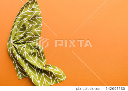 top view with green kitchen napkin isolated on table background. Folded cloth for mockup with copy space, Flat lay. Minimal style top view with green kitchen napkin isolated on table background. Folded cloth for mockup with copy space, Flat lay. Minimal style 142095380