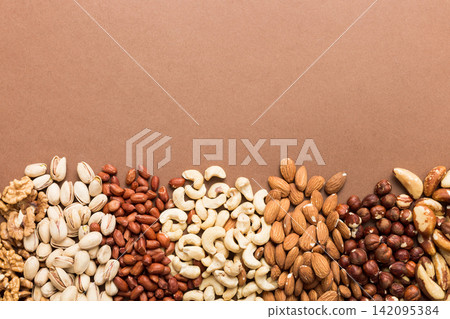 different nuts frame background. Close up, top view, flat lay with vopy space. Walnut, pistachios, almonds, hazelnuts and cashews different nuts frame background. Close up, top view, flat lay with vopy space. Walnut, pistachios, almonds, hazelnuts and cashews 142095384