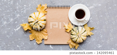 Autumn composition: fallen leaves and craft sketchbook mock up on colored background. Top view. Flat lay with copy space Autumn composition: fallen leaves and craft sketchbook mock up on colored background. Top view. Flat lay with copy space 142095461