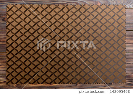 Top view of brown tablecloth for food on wooden background. Empty space for your design Top view of brown tablecloth for food on wooden background. Empty space for your design 142095468