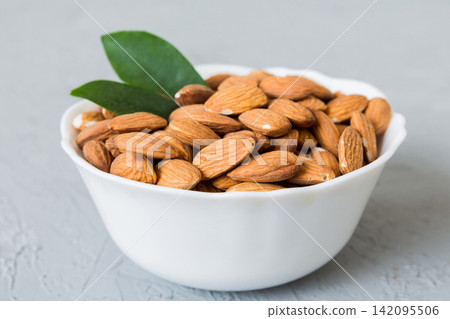 Fresh healthy Almond in bowl on colored table background. Top view Fresh healthy Almond in bowl on colored table background. Top view 142095506