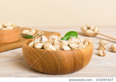 Fresh healthy Pistachios in bowl on colored table background. Top view Healthy eating concept. Super foods Fresh healthy Pistachios in bowl on colored table background. Top view Healthy eating concept. Super foods 142095507