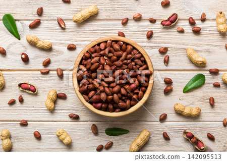 Fresh healthy peanuts in bowl on colored table background. Top view Healthy eating bertholletia concept. Super foods Fresh healthy peanuts in bowl on colored table background. Top view Healthy eating bertholletia concept. Super foods 142095513