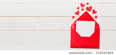 Red paper envelope with empty white card and heart on colored background. top view valentines day concept Red paper envelope with empty white card and heart on colored background. top view valentines day concept 142095864