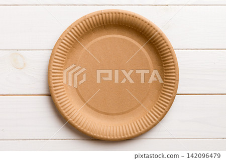 Top view of eco paper plate on wooden background. Empty space for your design Top view of eco paper plate on wooden background. Empty space for your design 142096479