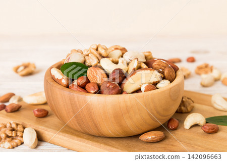 mixed nuts in bowl. Mix of various nuts on colored background. pistachios, cashews, walnuts, hazelnuts, peanuts and brazil nuts mixed nuts in bowl. Mix of various nuts on colored background. pistachios, cashews, walnuts, hazelnuts, peanuts and brazil nuts 142096663