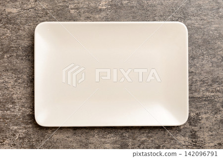 Top view of empty square plate on cement background. Empty space for your design Top view of empty square plate on cement background. Empty space for your design 142096791