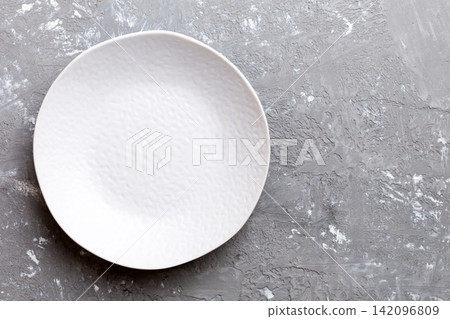 Top view of empty light plate on cement background. Empty space for your design Top view of empty light plate on cement background. Empty space for your design 142096809