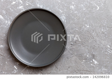 Top view of black plate on cement background. Empty space for your design Top view of black plate on cement background. Empty space for your design 142096810
