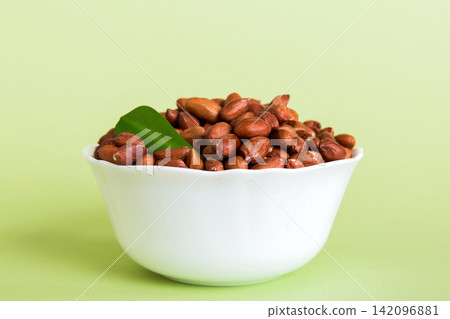 Fresh healthy peanuts in bowl on colored table background. Top view Healthy eating bertholletia concept. Super foods Fresh healthy peanuts in bowl on colored table background. Top view Healthy eating bertholletia concept. Super foods 142096881