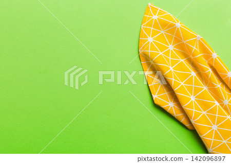top view with yellow empty kitchen napkin isolated on table background. Folded cloth for mockup with copy space, Flat lay. Minimal style top view with yellow empty kitchen napkin isolated on table background. Folded cloth for mockup with copy space, Flat lay. Minimal style 142096897