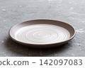 Perspective view of empty light plate on cement background. Empty space for your design 142097083
